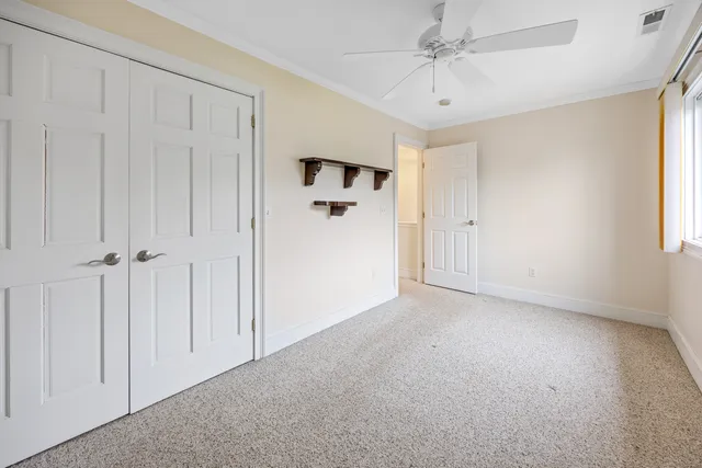 a view of a room with a ceiling fan and window