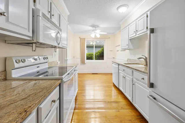 a kitchen with stainless steel appliances granite countertop lots of counter top space and wooden floor