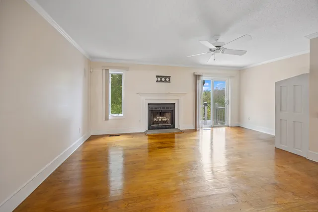 a view of an empty room with a fireplace and a window