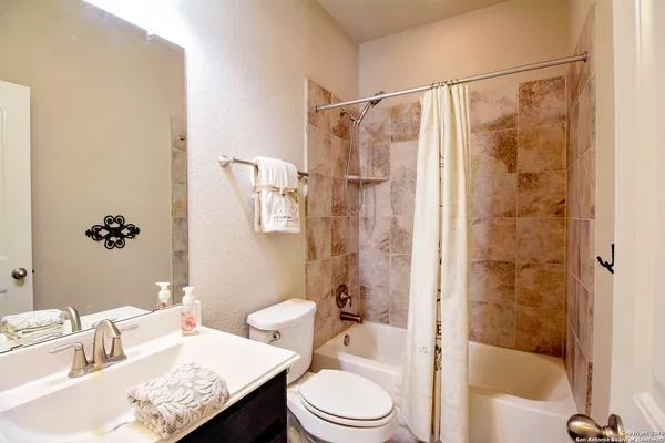 a kitchen with stainless steel appliances granite countertop a sink dishwasher stove and white cabinets with wooden floor