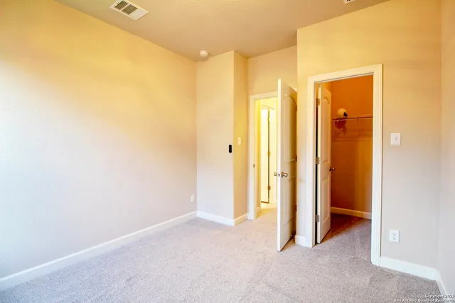 a view of a hallway with wooden floor and a cabinet
