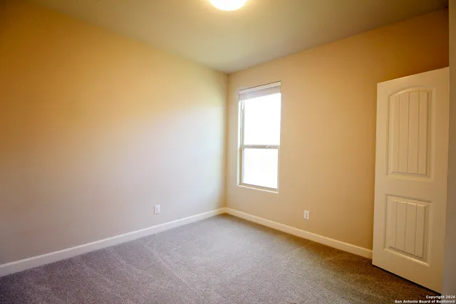 a view of an empty room with glass door and windows