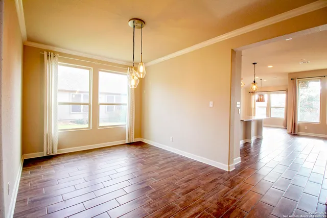 a large kitchen with granite countertop a stove a sink a window and dining table