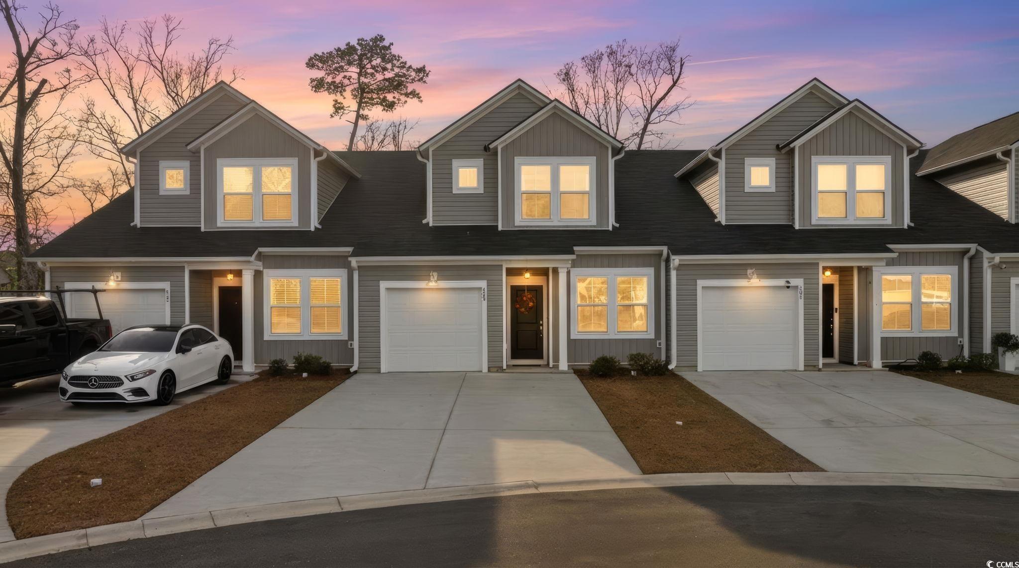 View of front facade featuring driveway and a garage