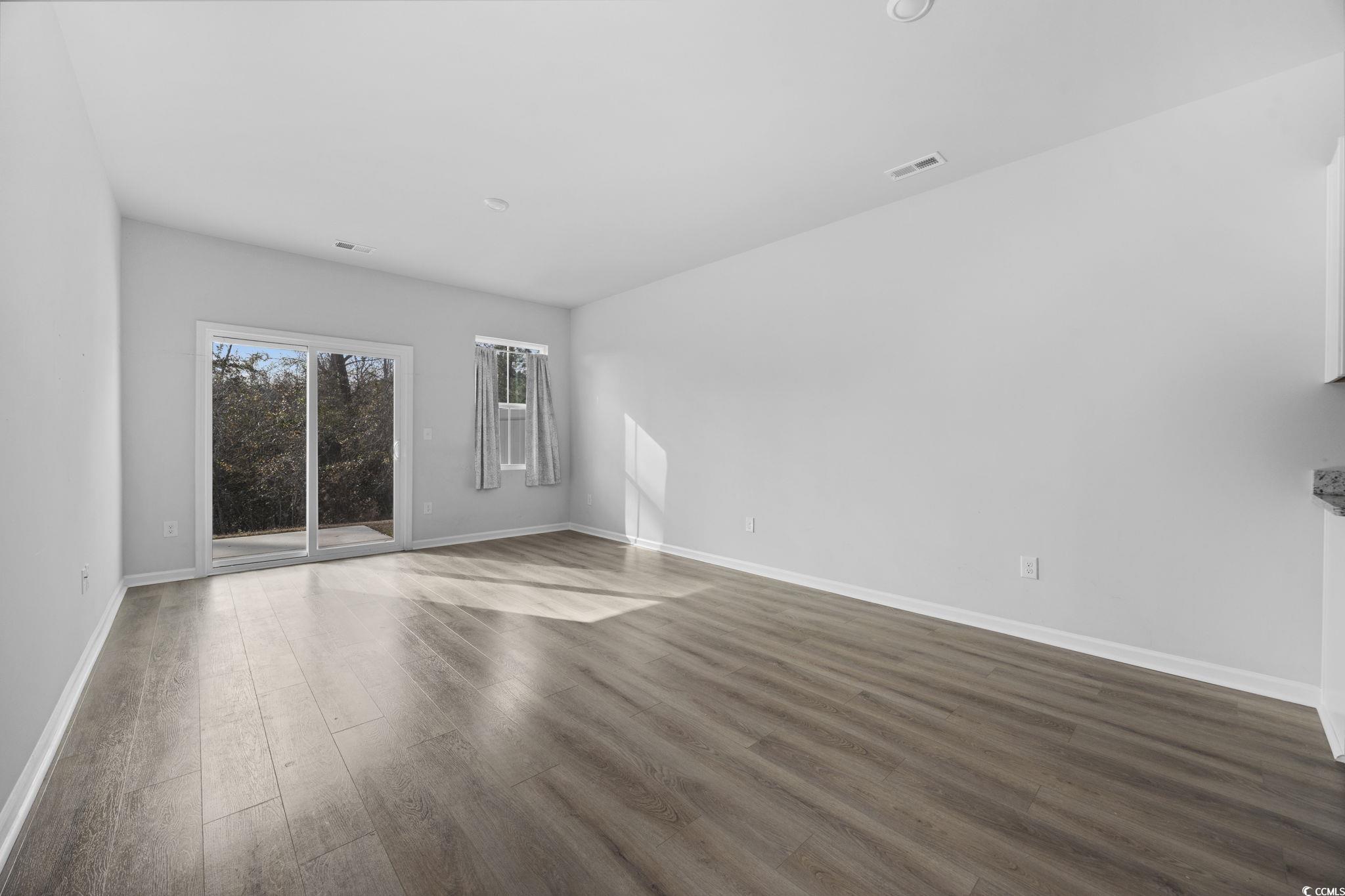 608 Sea Sparrow Street, Unit 608 Myrtle Beach, SC 29588 - Photo 13 of 37 Empty room with dark wood-style flooring and baseboards