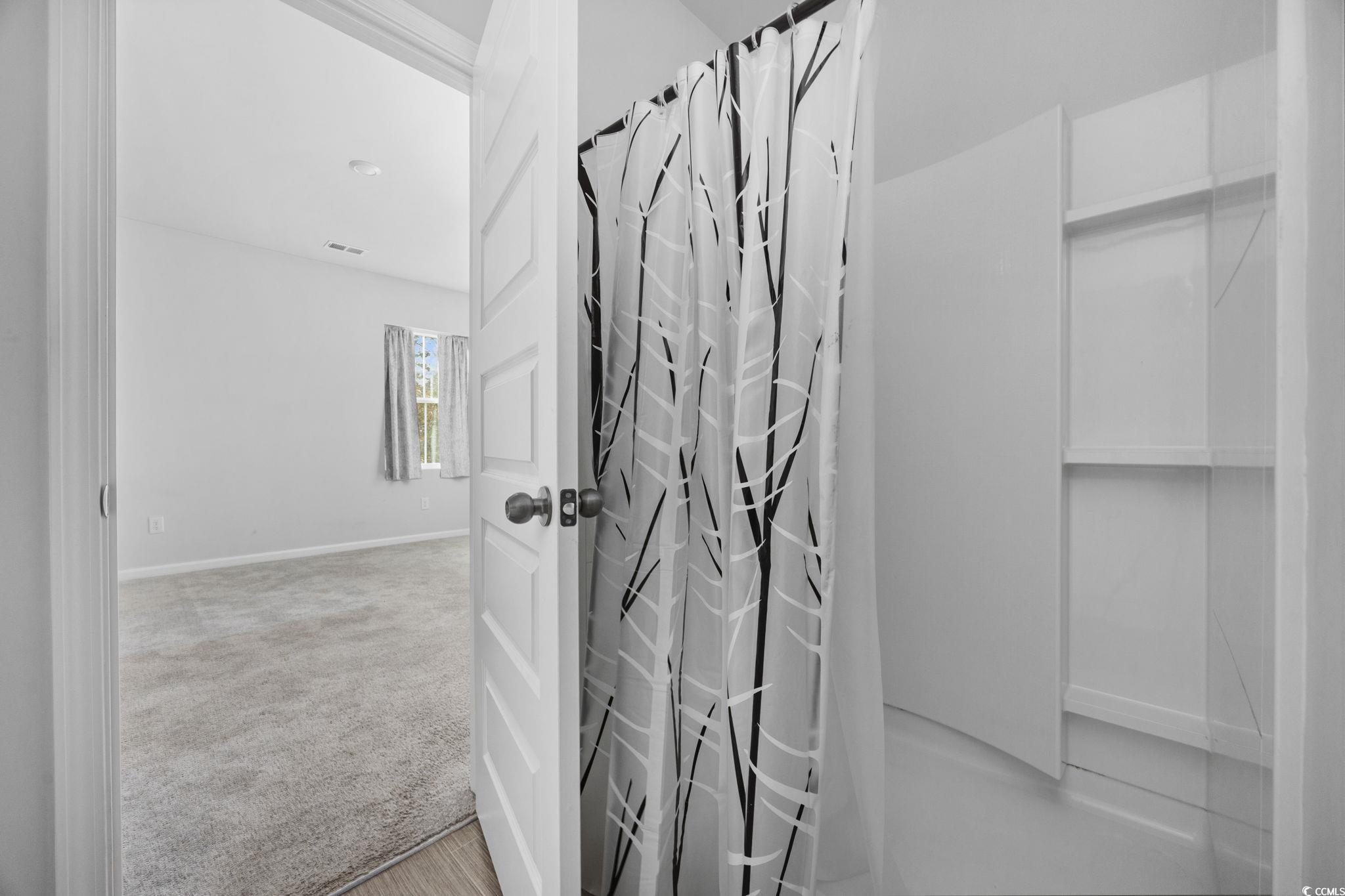 608 Sea Sparrow Street, Unit 608 Myrtle Beach, SC 29588 - Photo 20 of 37 Bathroom featuring a shower with curtain and light carpet