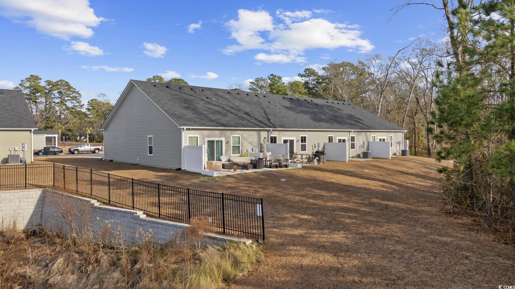 608 Sea Sparrow Street, Unit 608 Myrtle Beach, SC 29588 - Photo 28 of 37 Rear view of property featuring a patio area, a fenced backyard, and a shingled roof