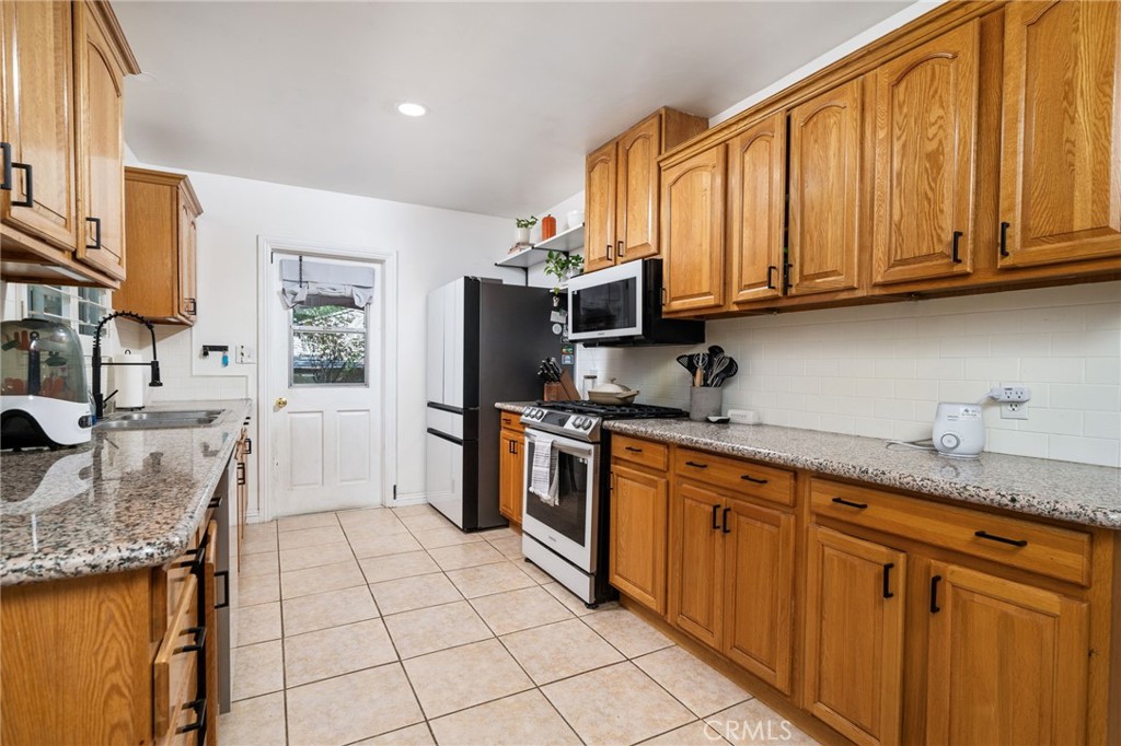 1995 Rincon Avenue Riverside, CA 92506 - Photo 8 of 18 a kitchen with stainless steel appliances granite countertop a stove a sink and a microwave