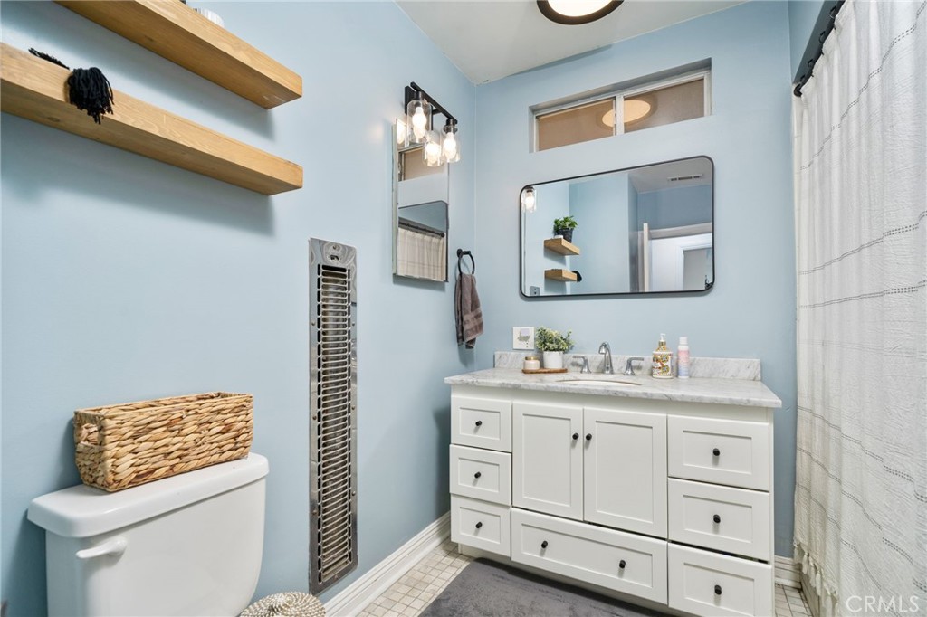 1995 Rincon Avenue Riverside, CA 92506 - Photo 10 of 18 a bathroom with a toilet a sink and mirror