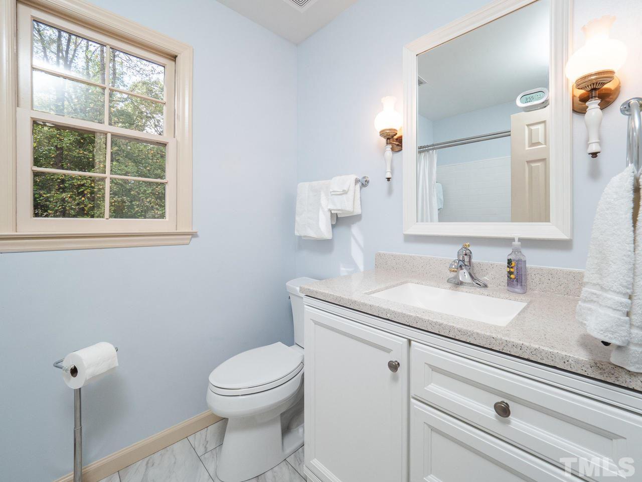 7705 Valley Run Drive Raleigh, NC 27615 - Photo 16 of 27 a bathroom with a granite countertop toilet sink and mirror