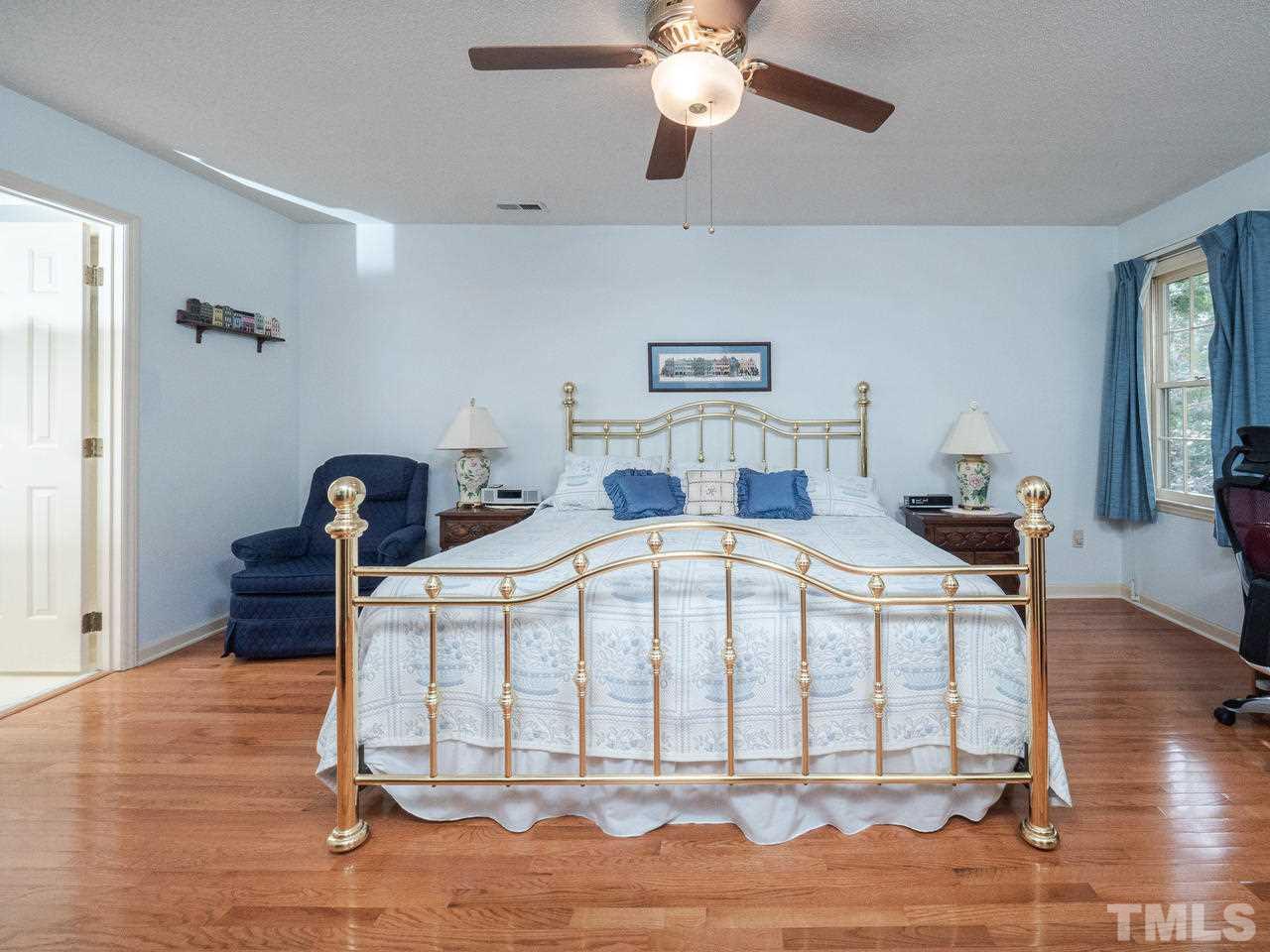 7705 Valley Run Drive Raleigh, NC 27615 - Photo 17 of 27 a bedroom with a bed and wooden floor