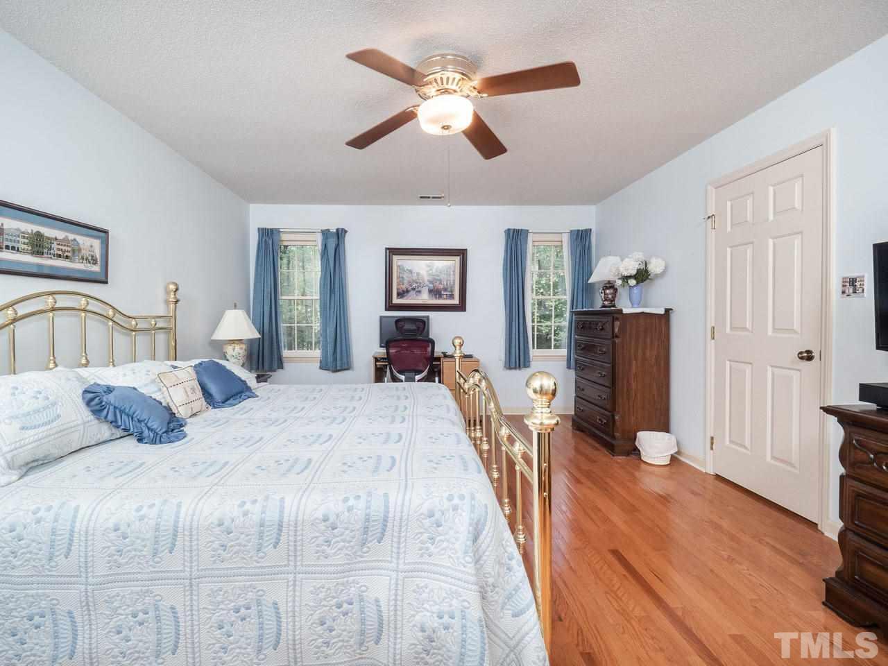 7705 Valley Run Drive Raleigh, NC 27615 - Photo 18 of 27 a spacious bedroom with a bed and wooden floor
