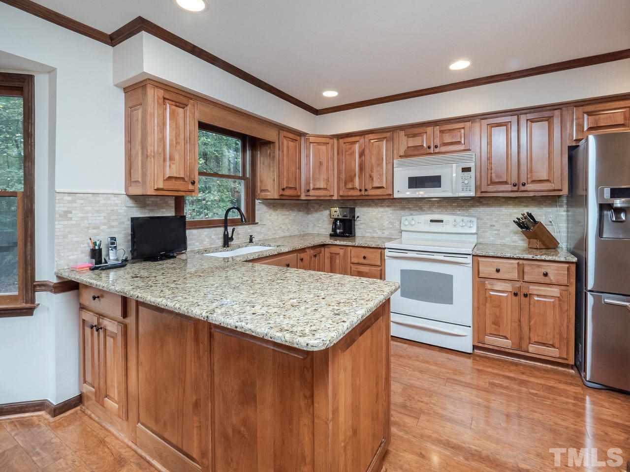 7705 Valley Run Drive Raleigh, NC 27615 - Photo 5 of 27 a kitchen with stainless steel appliances granite countertop a sink stove microwave and refrigerator