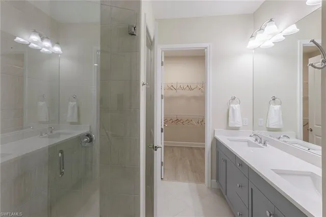 a bathroom with a double vanity sink mirror and shower