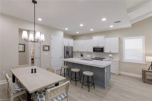 a kitchen that has a table chairs and a refrigerator