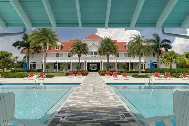 a view of a swimming pool with a lawn chairs under an umbrella