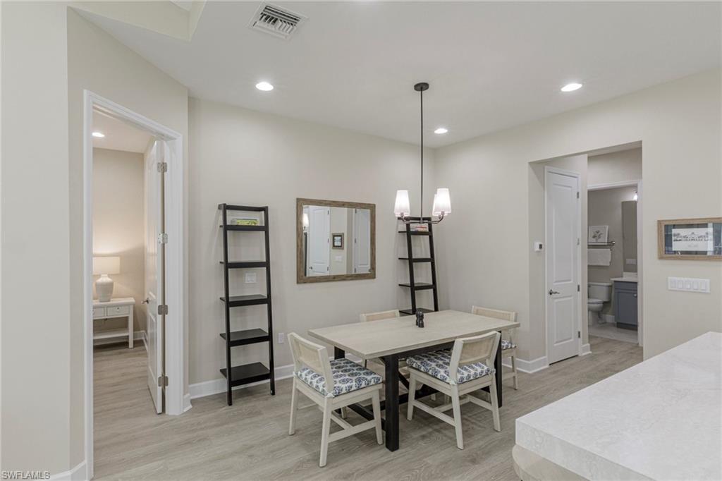 7184 Cayo Coco Lane Naples, FL 34113 - Photo 7 of 40 a view of a dining room with furniture and wooden floor