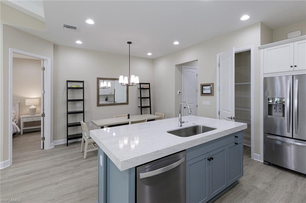 7184 Cayo Coco Lane Naples, FL 34113 - Photo 8 of 40 a kitchen with a sink and refrigerator