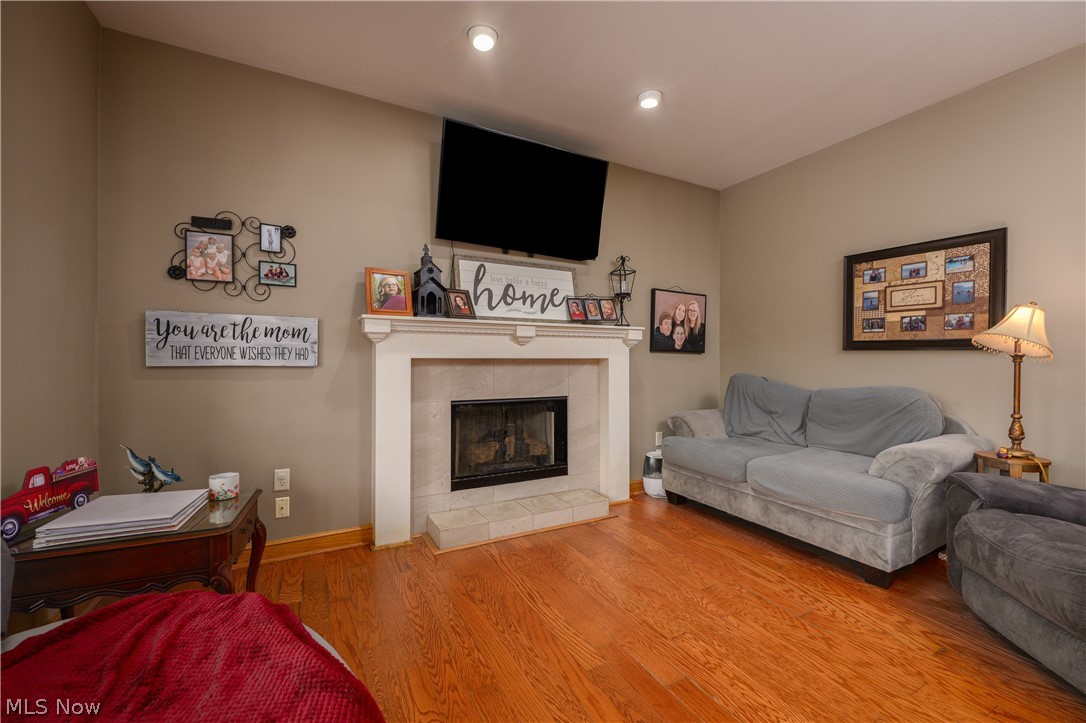 806 Forrest Ridge Drive Dover, OH 44622 - Photo 12 of 36 Living room featuring wood finished floors, a tiled fireplace, and recessed lighting