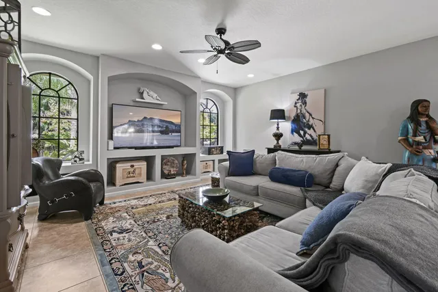 a living room with furniture ceiling fan and a window