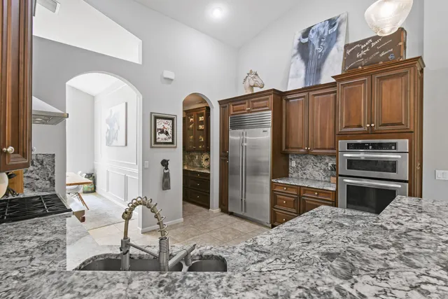 a kitchen with stainless steel appliances kitchen island granite countertop a refrigerator and cabinets