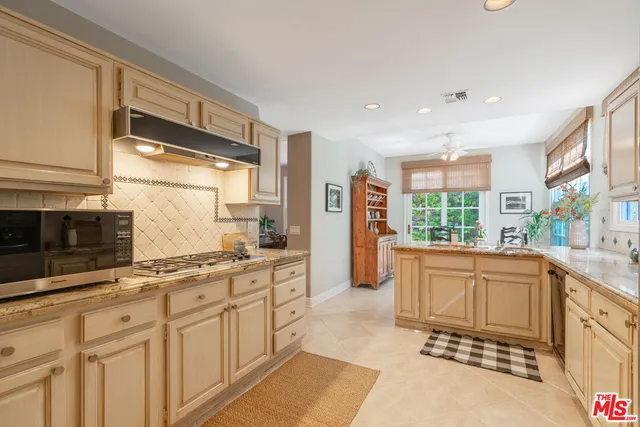 a large kitchen with stainless steel appliances granite countertop a sink and a stove