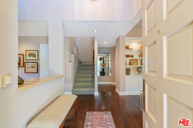 a hallway with wooden floor and furniture