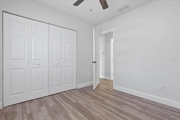 a view of an empty room with closet and a window