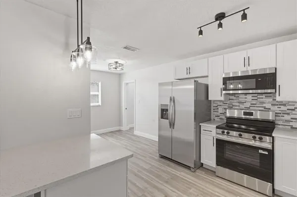 a kitchen with stainless steel appliances a refrigerator stove and microwave