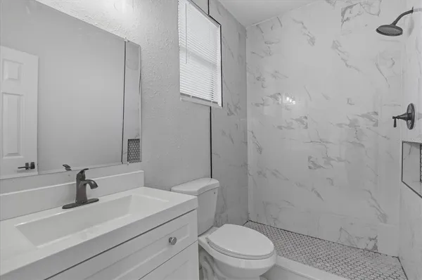 a bathroom with a sink a toilet and shower