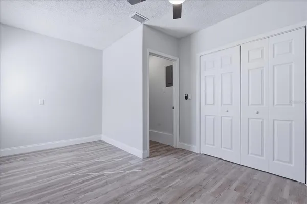 a view of an empty room with closet and a window