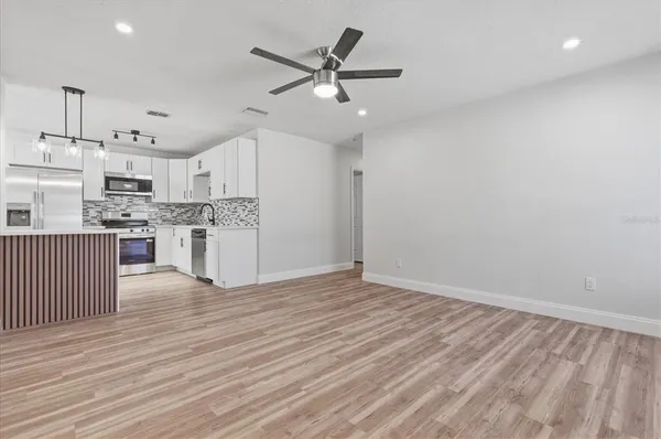 a view of a kitchen with a sink and dishwasher a refrigerator with wooden floor