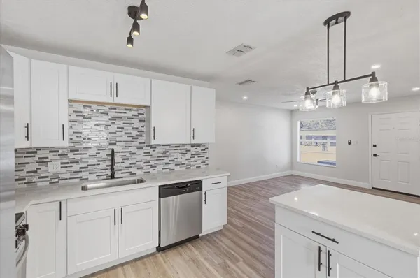 a kitchen with kitchen island white cabinets and white appliances