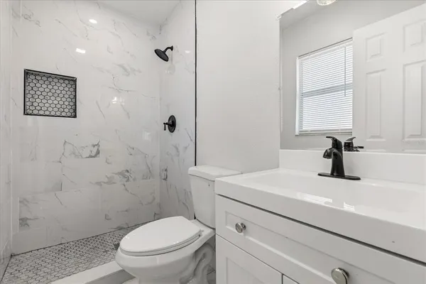 a bathroom with a sink a toilet and shower