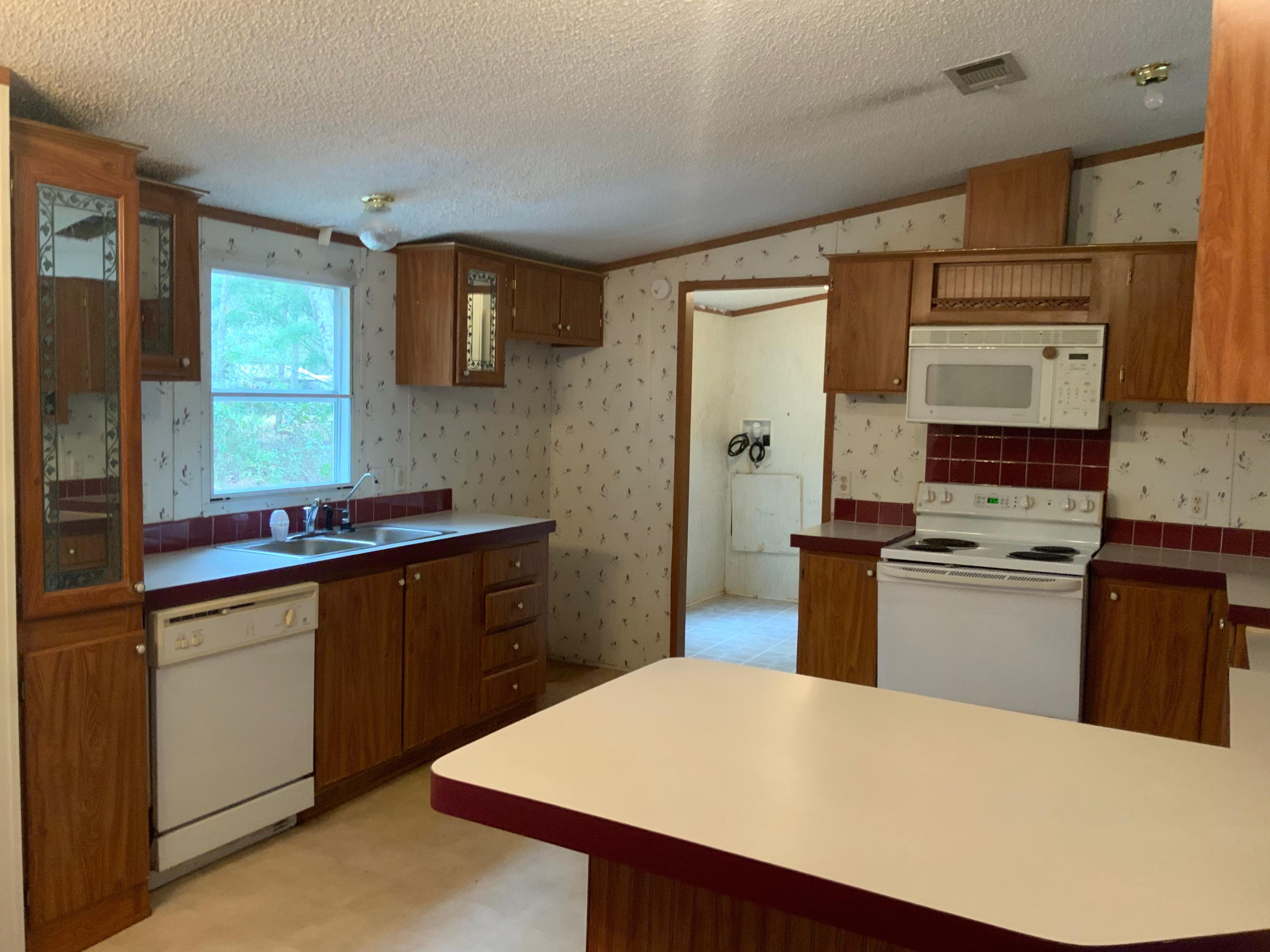 126 South 3rd Street Santa Rosa Beach, FL 32459 - Photo 5 of 12 a kitchen with stainless steel appliances a sink stove and refrigerator