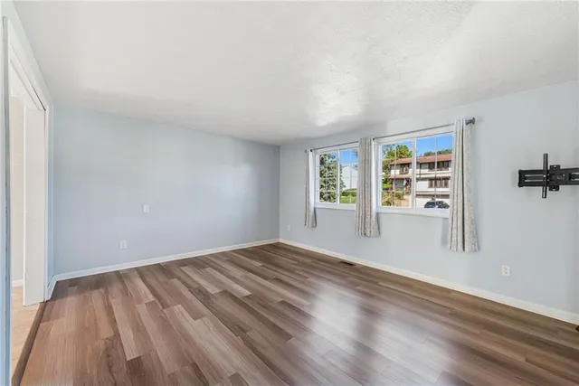 wooden floor in an empty room with a window