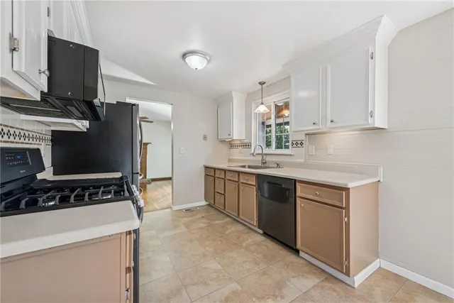 a kitchen with a refrigerator and a stove top oven