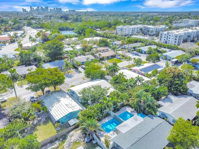an aerial view of residential houses with outdoor space and parking