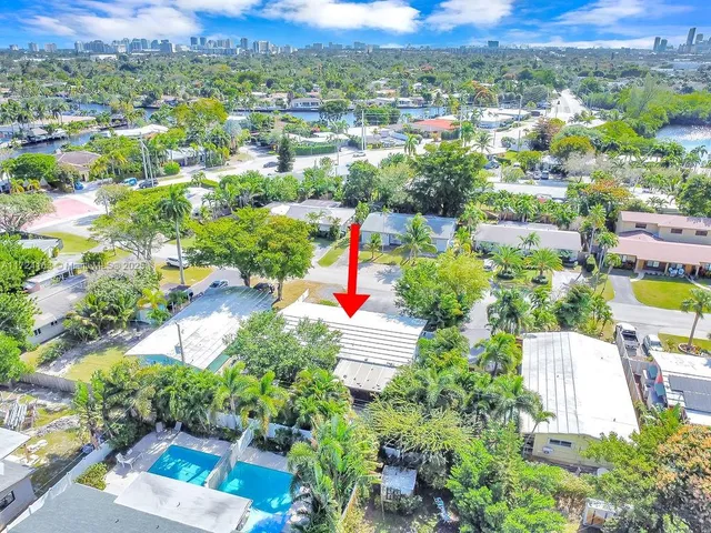 an aerial view of residential houses with outdoor space and trees