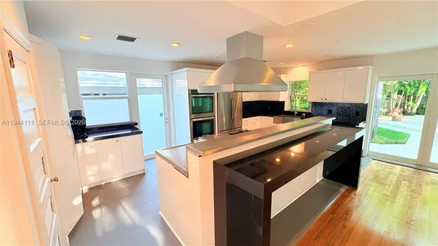 a kitchen with stainless steel appliances granite countertop a stove a sink and a microwave