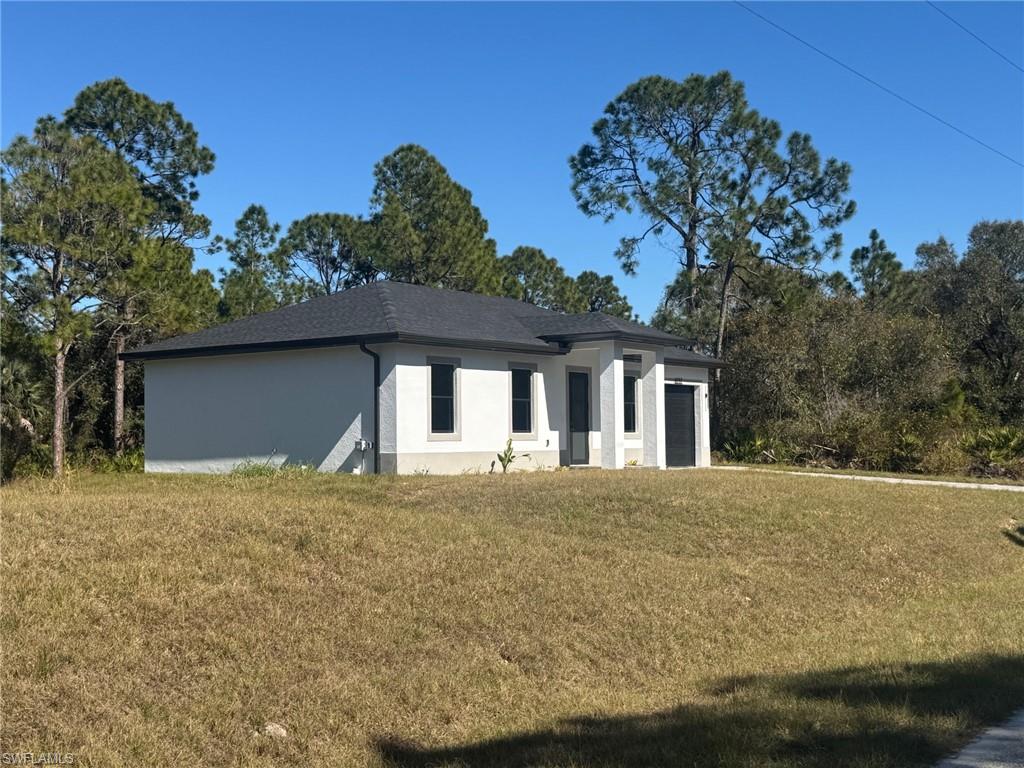 1127 Chipley Street Lehigh Acres, FL 33974 - Photo 2 of 8 front view of house with a yard