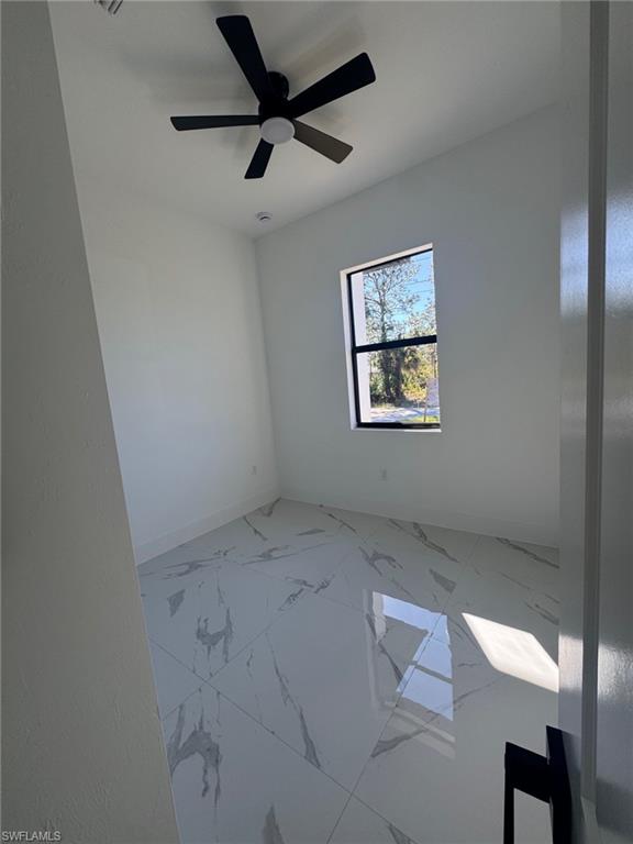 1127 Chipley Street Lehigh Acres, FL 33974 - Photo 3 of 8 an empty room with a window and a ceiling fan