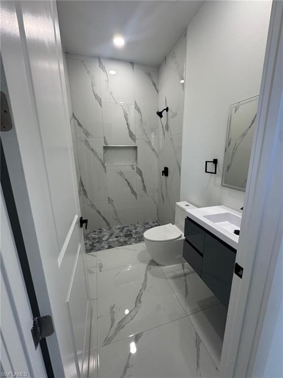 1127 Chipley Street Lehigh Acres, FL 33974 - Photo 6 of 8 a bathroom with a sink a toilet and shower