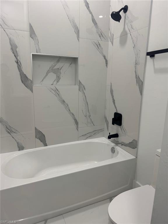 1127 Chipley Street Lehigh Acres, FL 33974 - Photo 7 of 8 a bathroom with a bathtub and a toilet