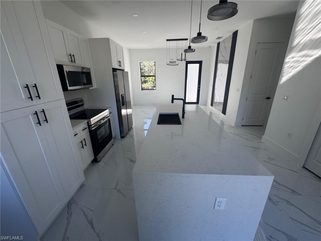 1127 Chipley Street Lehigh Acres, FL 33974 - Photo 8 of 8 a living room with stainless steel appliances wooden floor furniture and a window