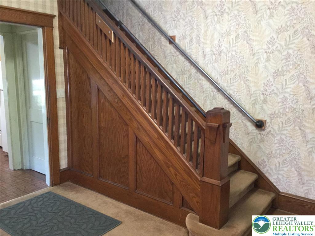 1105 Main Street Slatington, PA 18080 - Photo 4 of 31 Rich wood paneling and a detailed banister grace this classic interior stairway, offering timeless appeal.