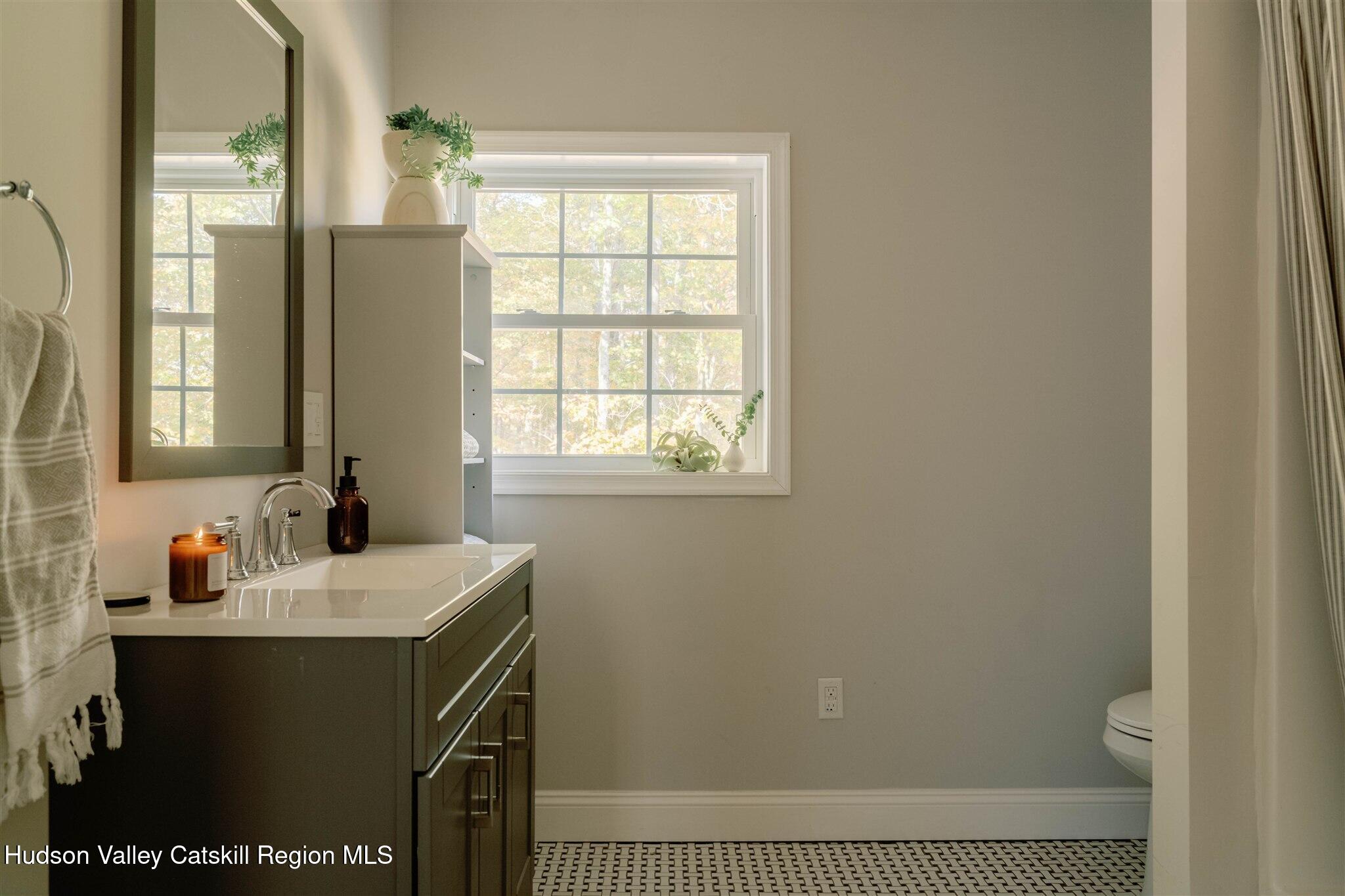 321 Mutton Hill Road Neversink, NY 12765 - Photo 17 of 25 a bathroom with a sink a vanity and a window
