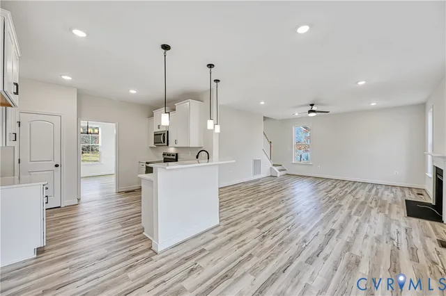 a kitchen with a sink cabinets stainless steel appliances and wooden floor