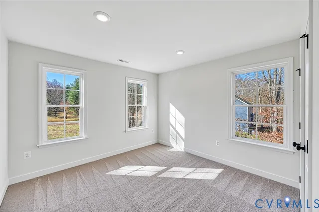 a view of an empty room with windows and closet