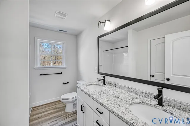 a bathroom with a granite countertop sink a mirror and shower